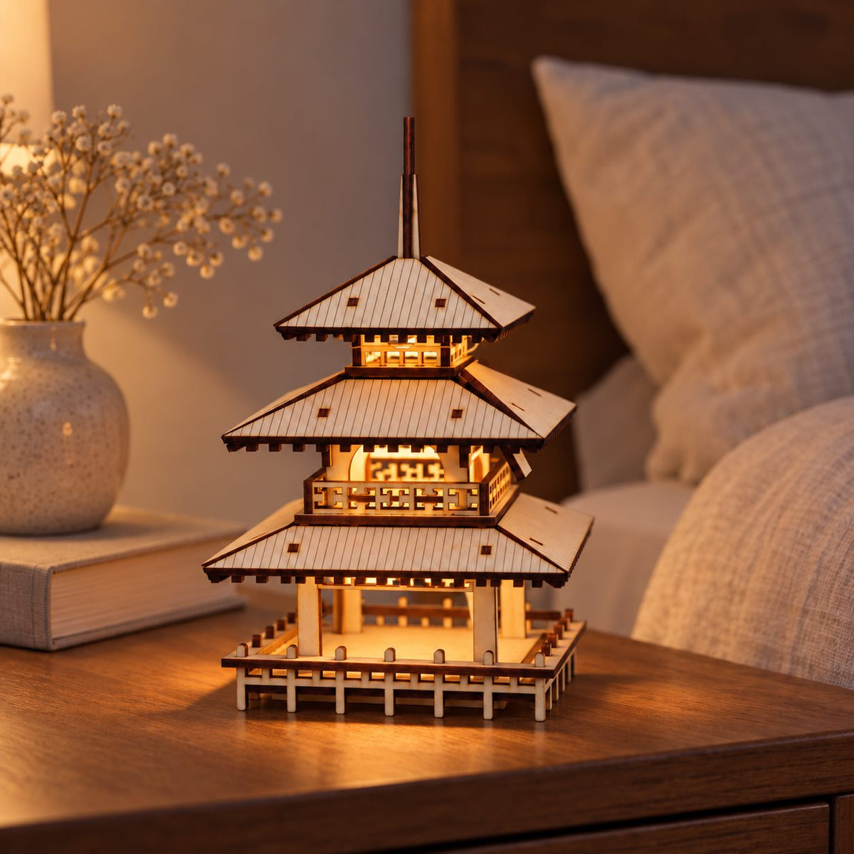 Three-Tier Pagoda styled on a bedside table with warm light illuminating its open galleries