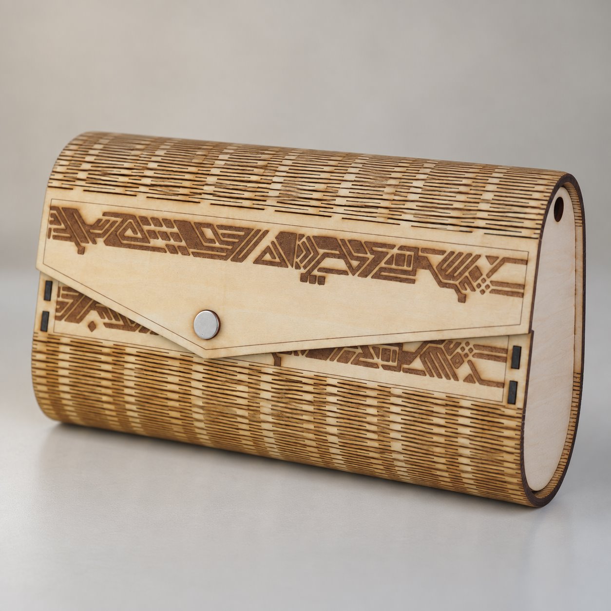 Close view of the envelope flap, round silver snap and fine cutwork of the wooden clutch